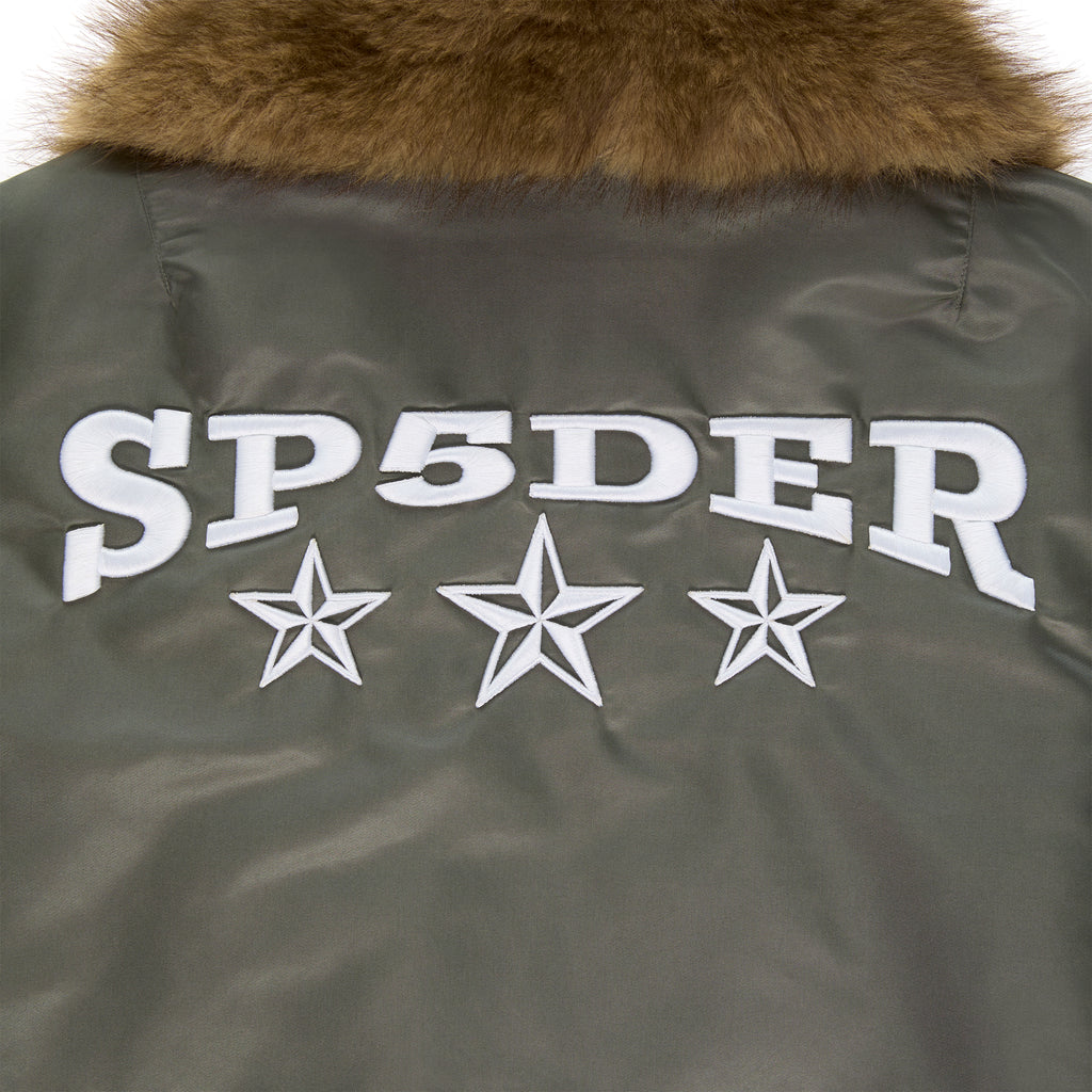 Olive nylon flight jacket with brown faux fur collar and white embroidered SP5DER graphic with stars.