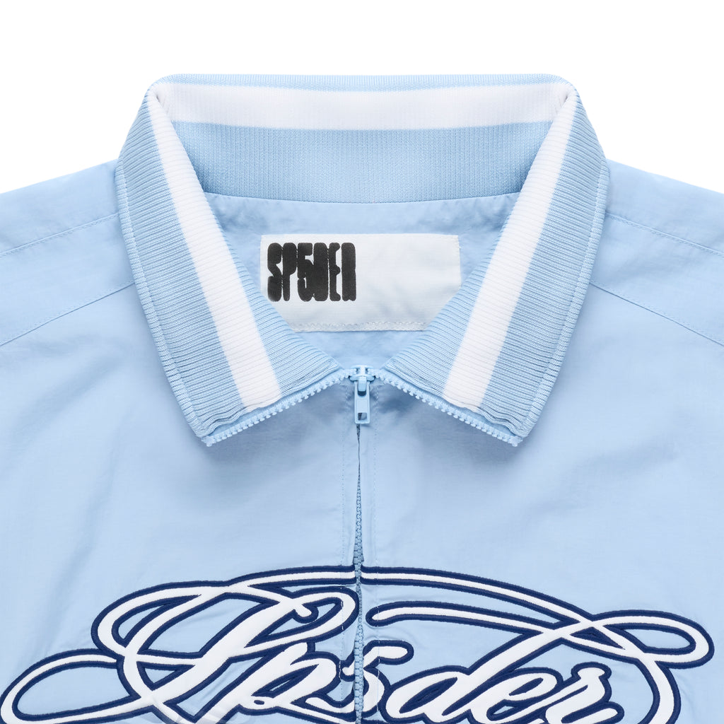 Light blue nylon track jacket with full zip, stand collar, and white/light blue ribbed trim.