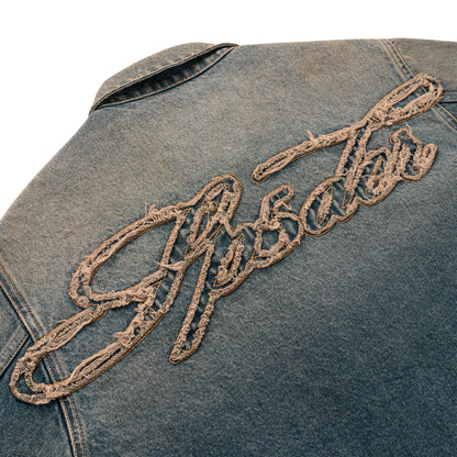 Blue denim work jacket with "Script" embroidered in distressed beige thread on the back.