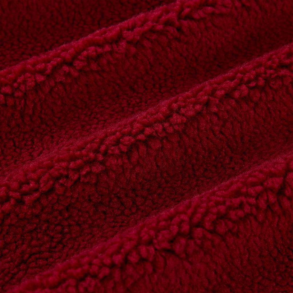 Close-up of plush red teddy sherpa fleece fabric with soft, textured loops and gentle folds.