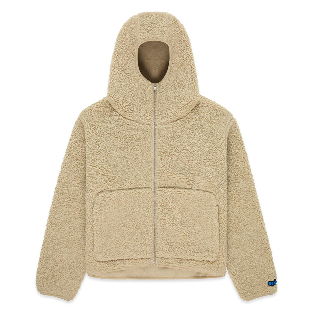 Beige sherpa fleece zip-up hooded jacket with narrow front opening, welt pockets, and rubberized logo patch.