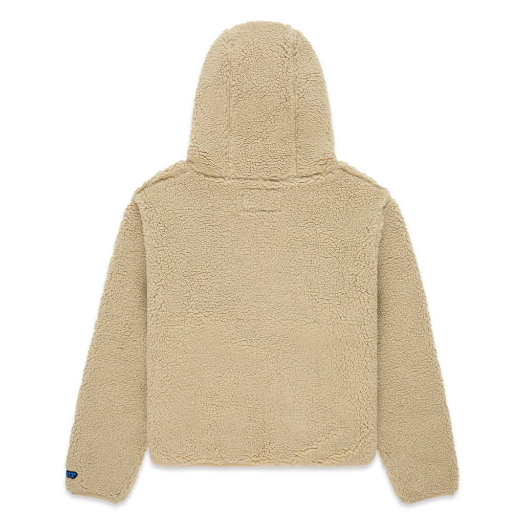 Back of a beige teddy sherpa fleece zip-up hooded jacket with a rubberized logo patch on the left wrist.