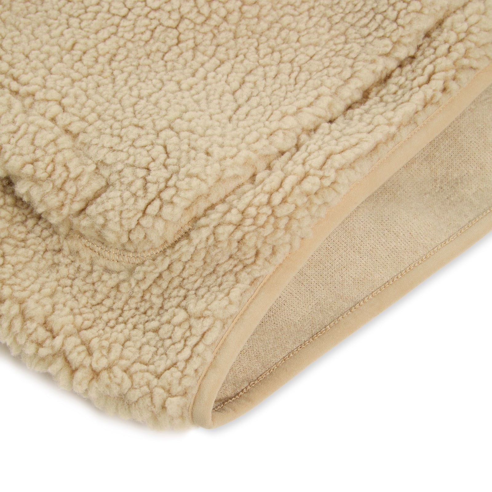Close-up of a beige teddy sherpa fleece fabric, showing its textured exterior and smooth inner lining.