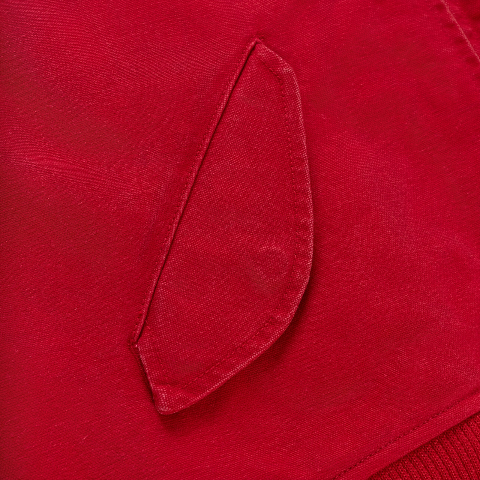 Close-up of a red cotton canvas bomber jacket with a flap pocket and ribbed hem.