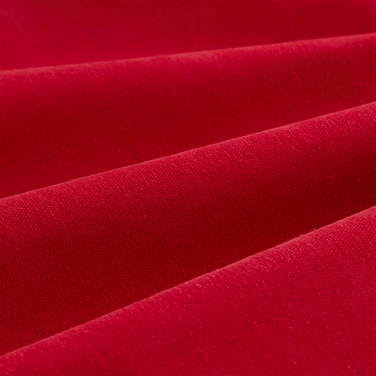 Close-up of vibrant red cotton canvas fabric, showing textured folds.