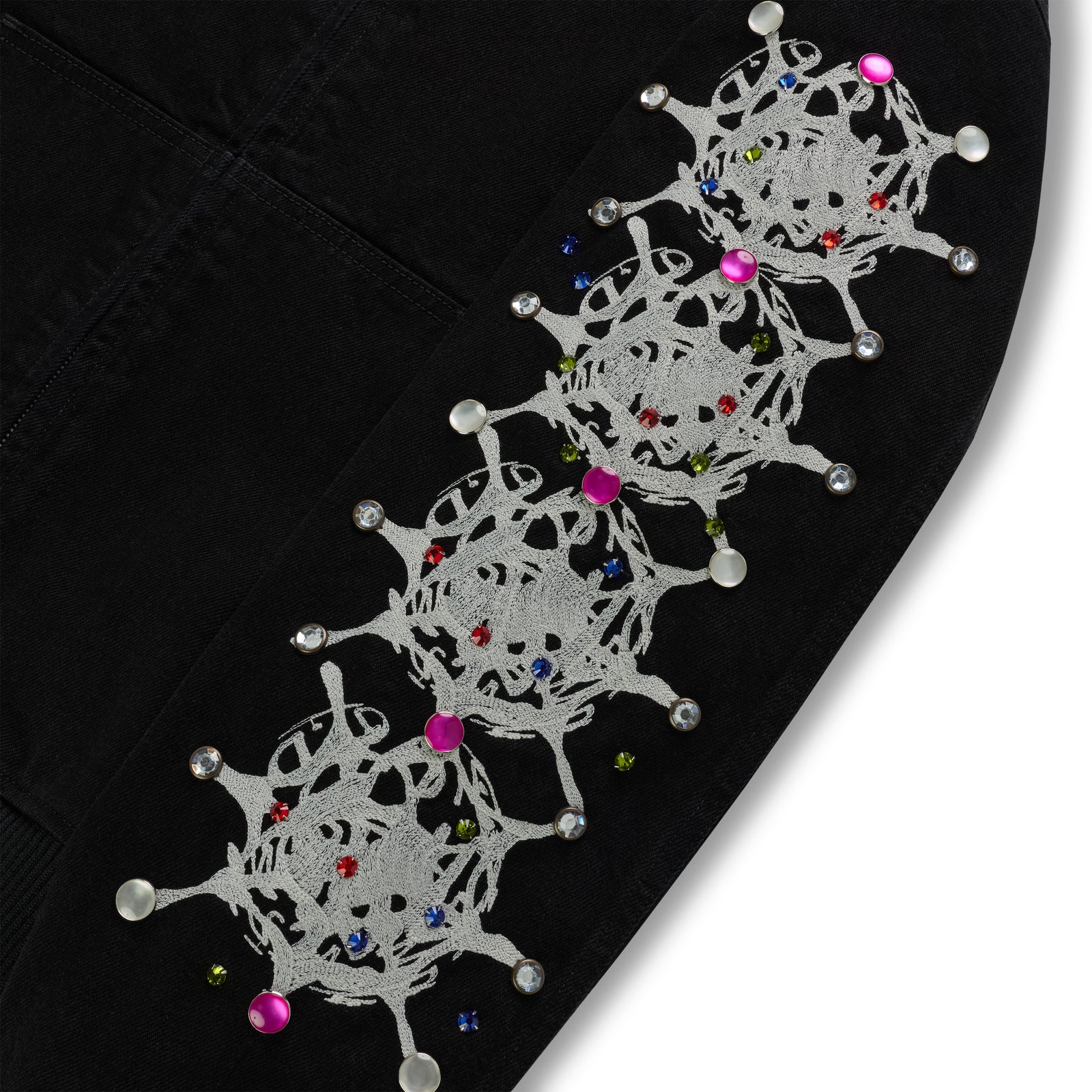 Black cotton canvas jacket sleeve with white web print and colorful rhinestone embellishments.