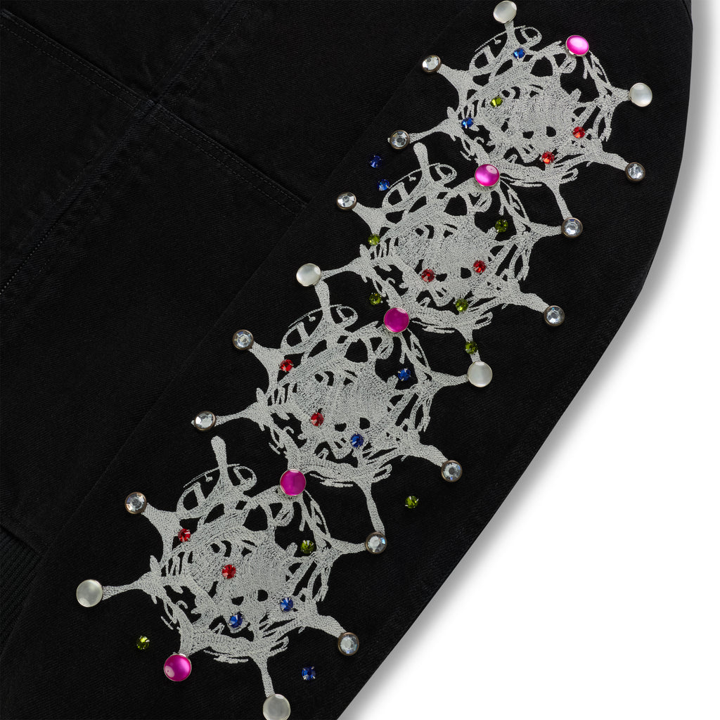 Black cotton canvas jacket sleeve with white web print and colorful rhinestone embellishments.