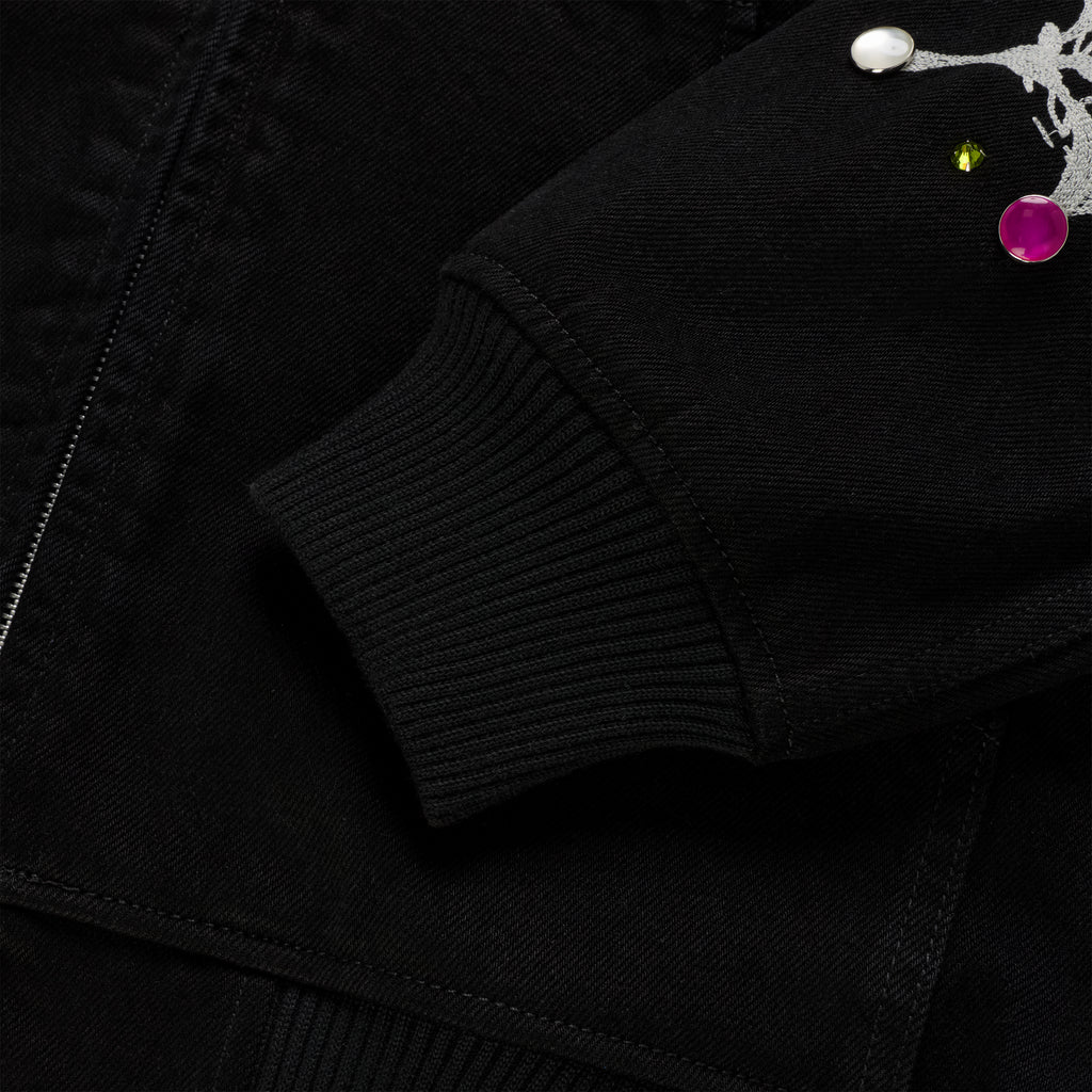 Black cotton canvas jacket sleeve with rib-knit cuff, zip closure, and colorful rhinestone embellishments.