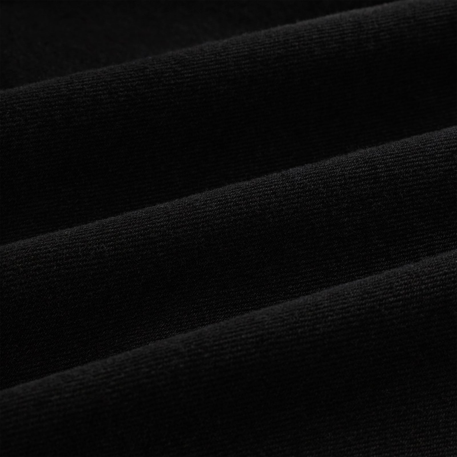 Close-up of black cotton canvas fabric, showing subtle texture and folds.