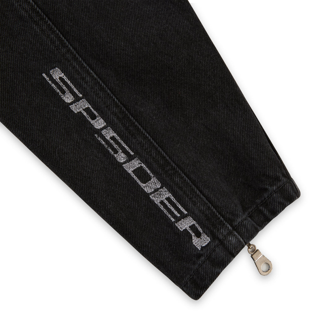 Black faded wash denim jacket sleeve with "SP5DER" embroidery and zip cuff.