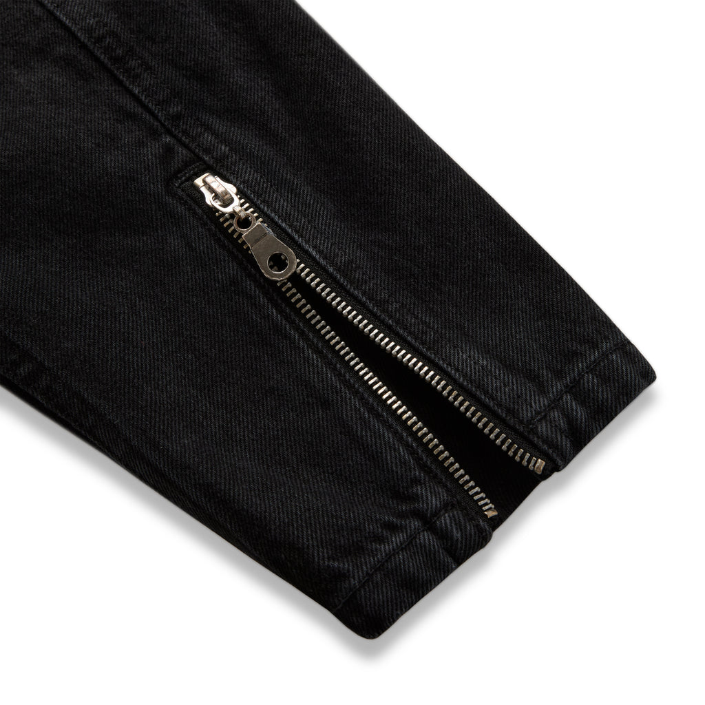 Faded black denim jacket sleeve with silver zip expansion panel at cuff.