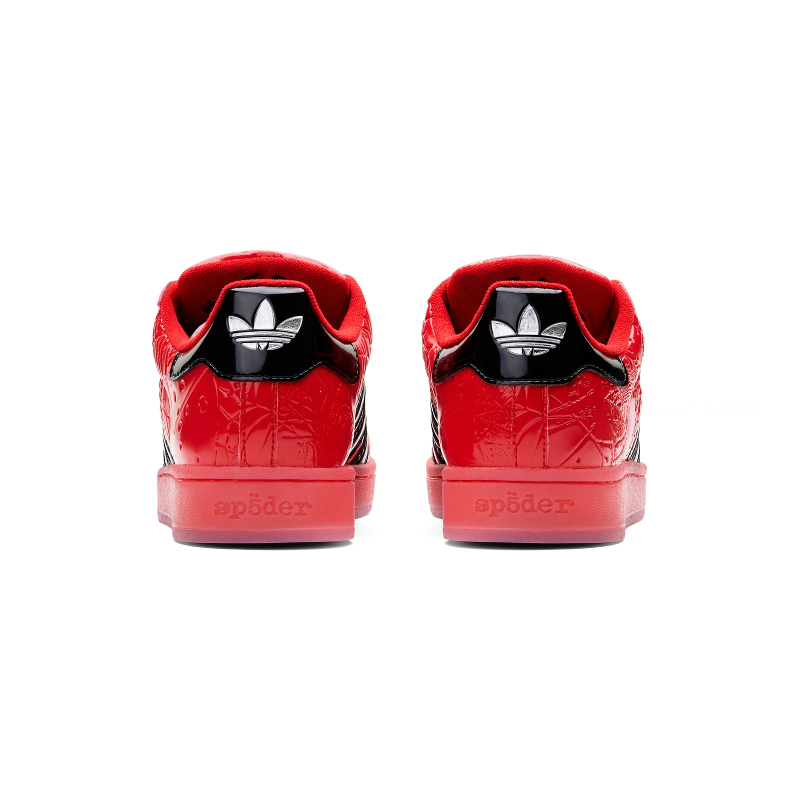 Red SP5DER x ADIDAS SUPERSTAR sneakers, showing glossy patent leather heels with black Adidas logos and "sp5der" text.