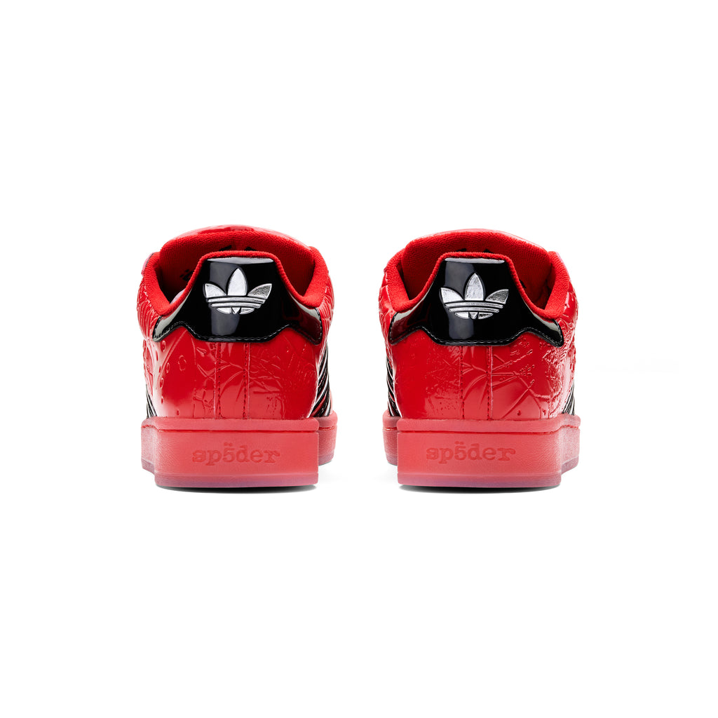Red SP5DER x ADIDAS SUPERSTAR sneakers, showing glossy patent leather heels with black Adidas logos and "sp5der" text.