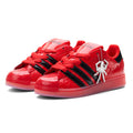 SP5DER x ADIDAS SUPERSTAR in glossy red patent leather with black stripes and a silver spider charm.