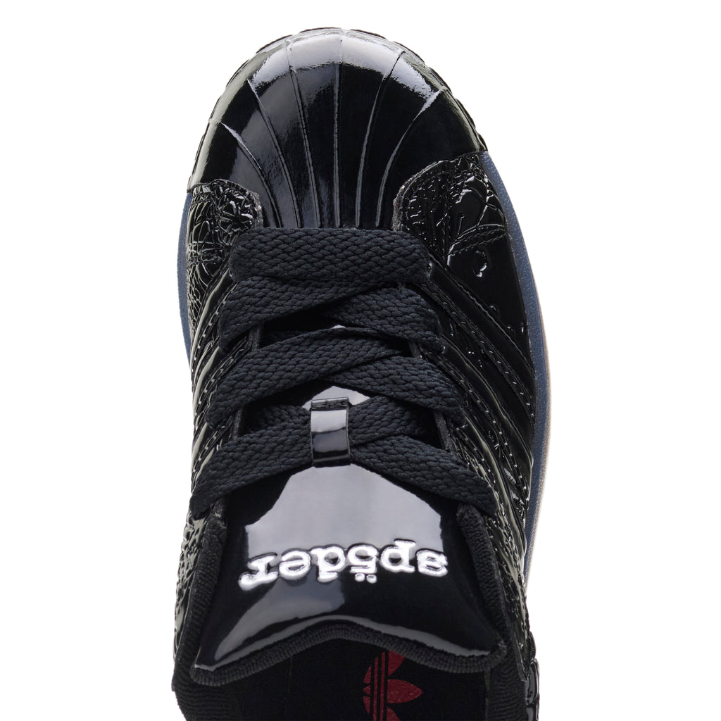 SP5DER x ADIDAS SUPERSTAR in black glossy patent leather with spider charm and "555" detail.
