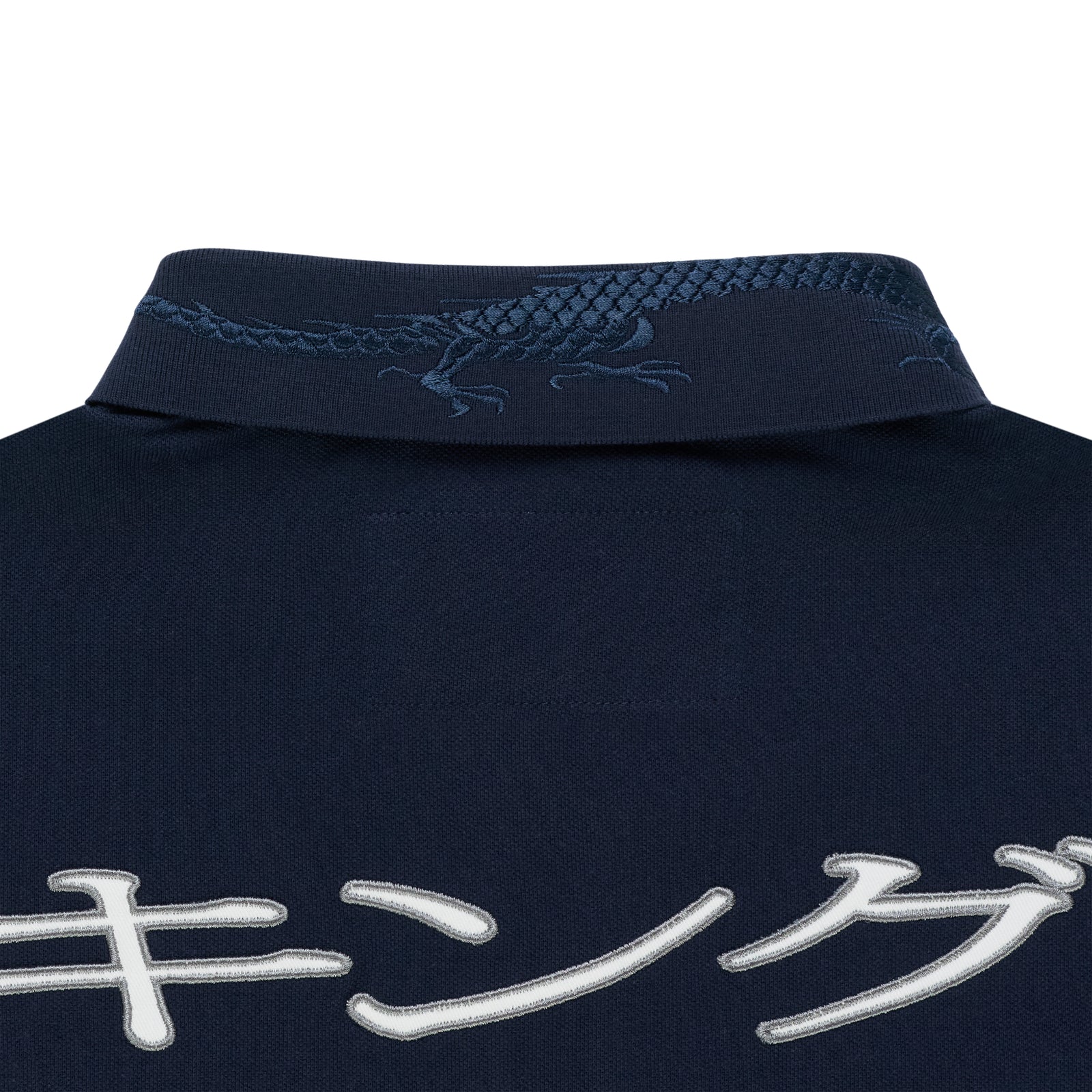 Navy polo shirt with embroidered dragon on the collar and white Japanese script on the back.
