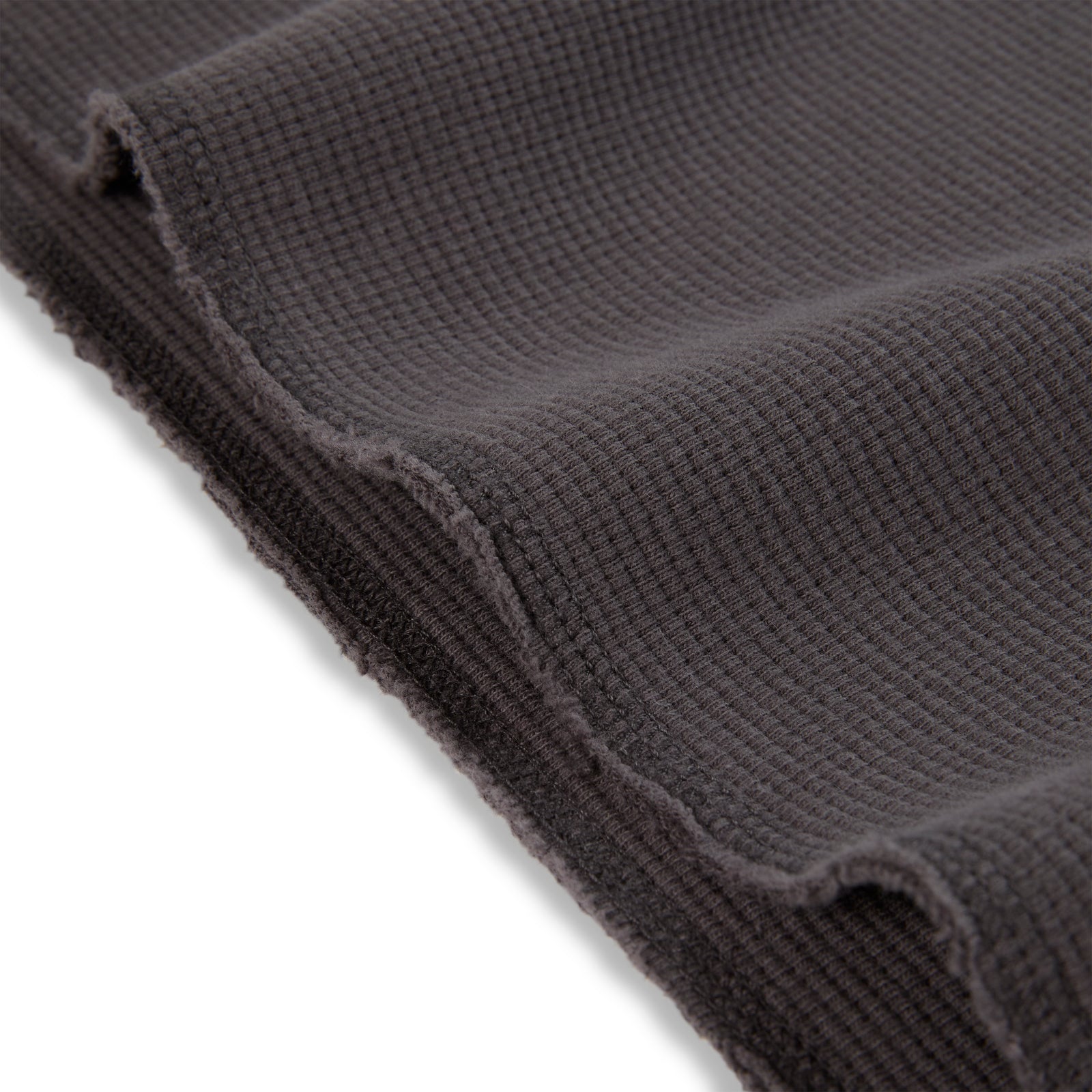 Dark grey waffle knit thermal fabric with raw edge detail.