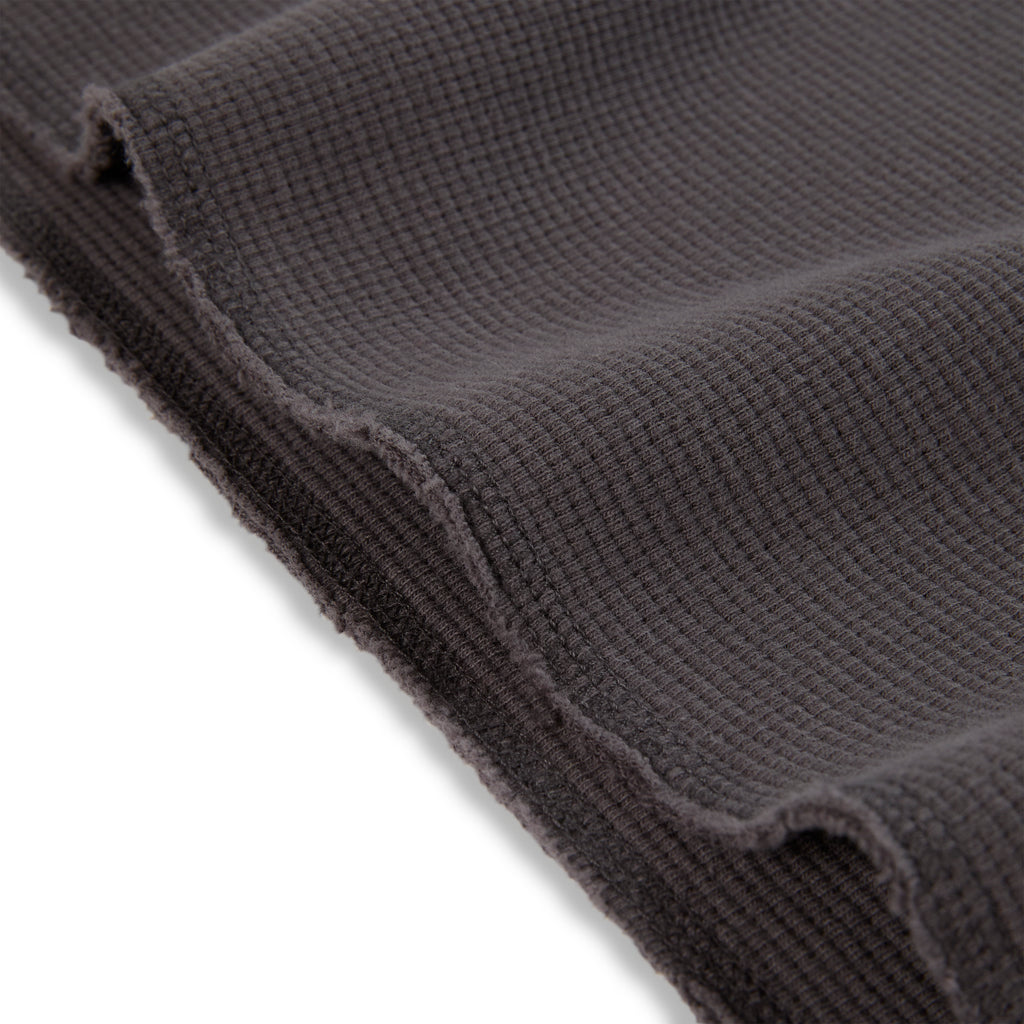 Dark grey waffle knit thermal fabric with raw edge detail.