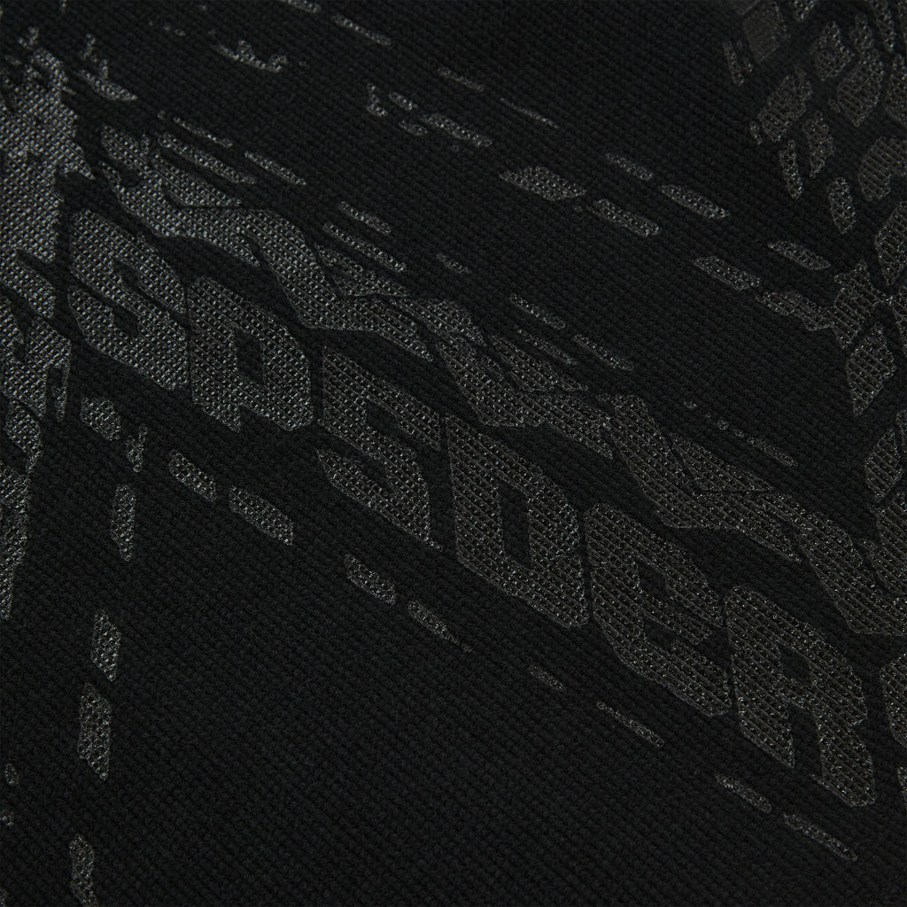 Close-up of black waffle knit thermal with subtle tire track print.