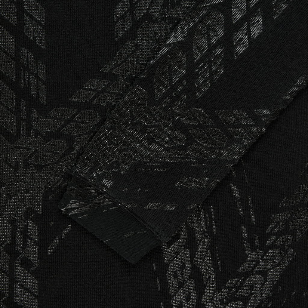 Black waffle knit thermal with subtle tire track print, ribbed cuff.
