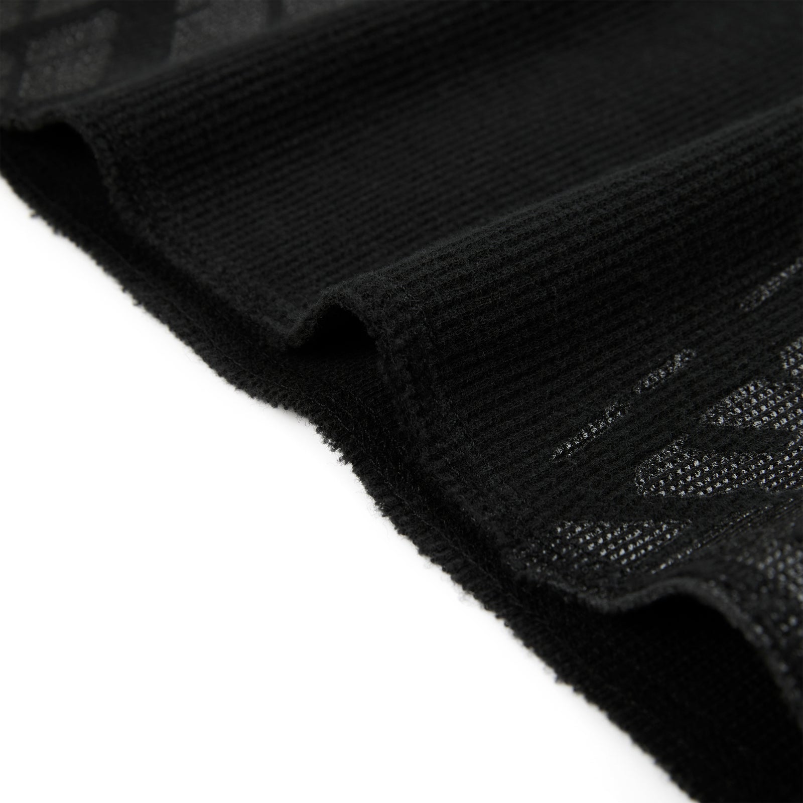Black waffle knit thermal with ribbed details and subtle tire track print.