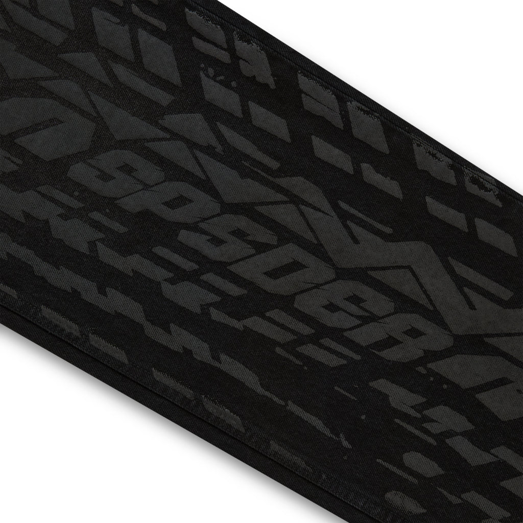 Black denim pant with all-over dark gray tire track design.