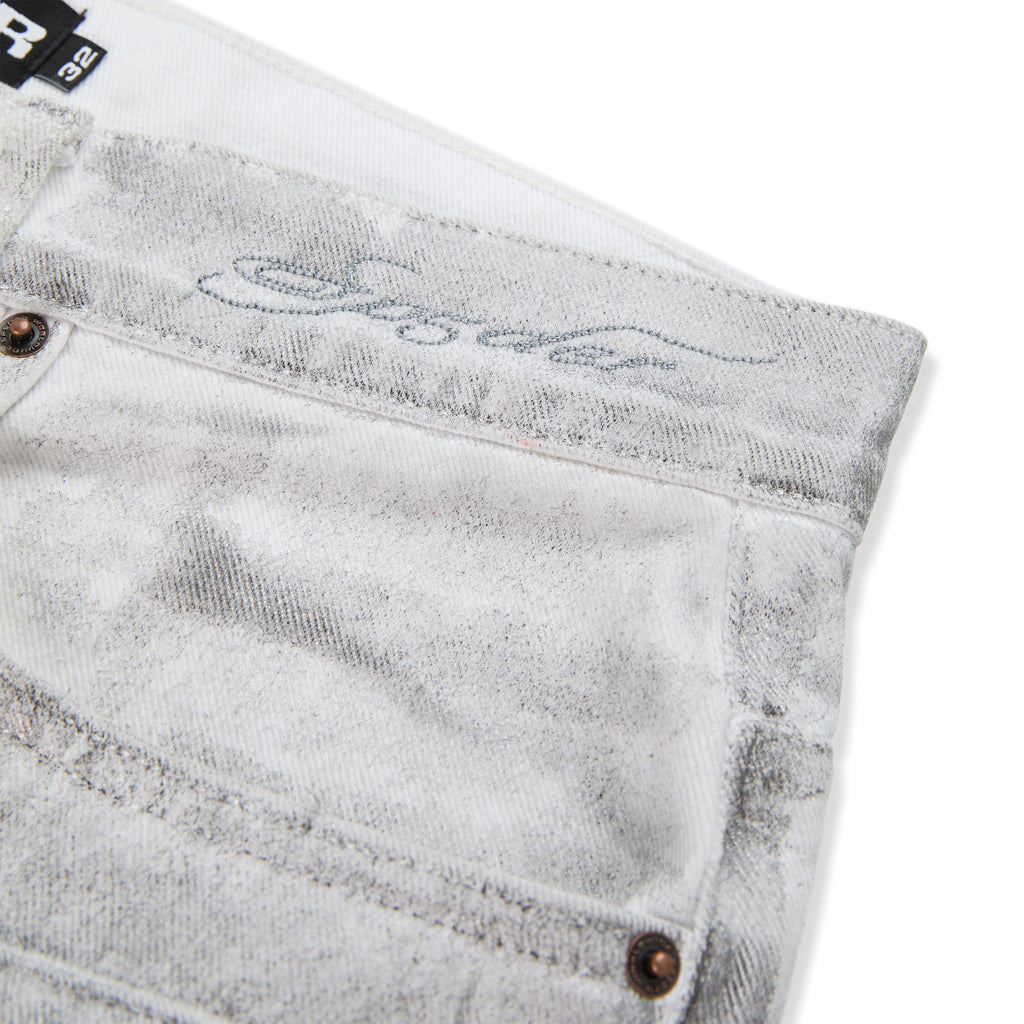 Platinum denim pant with spray-effect finish, custom hardware, and embroidered waistband.