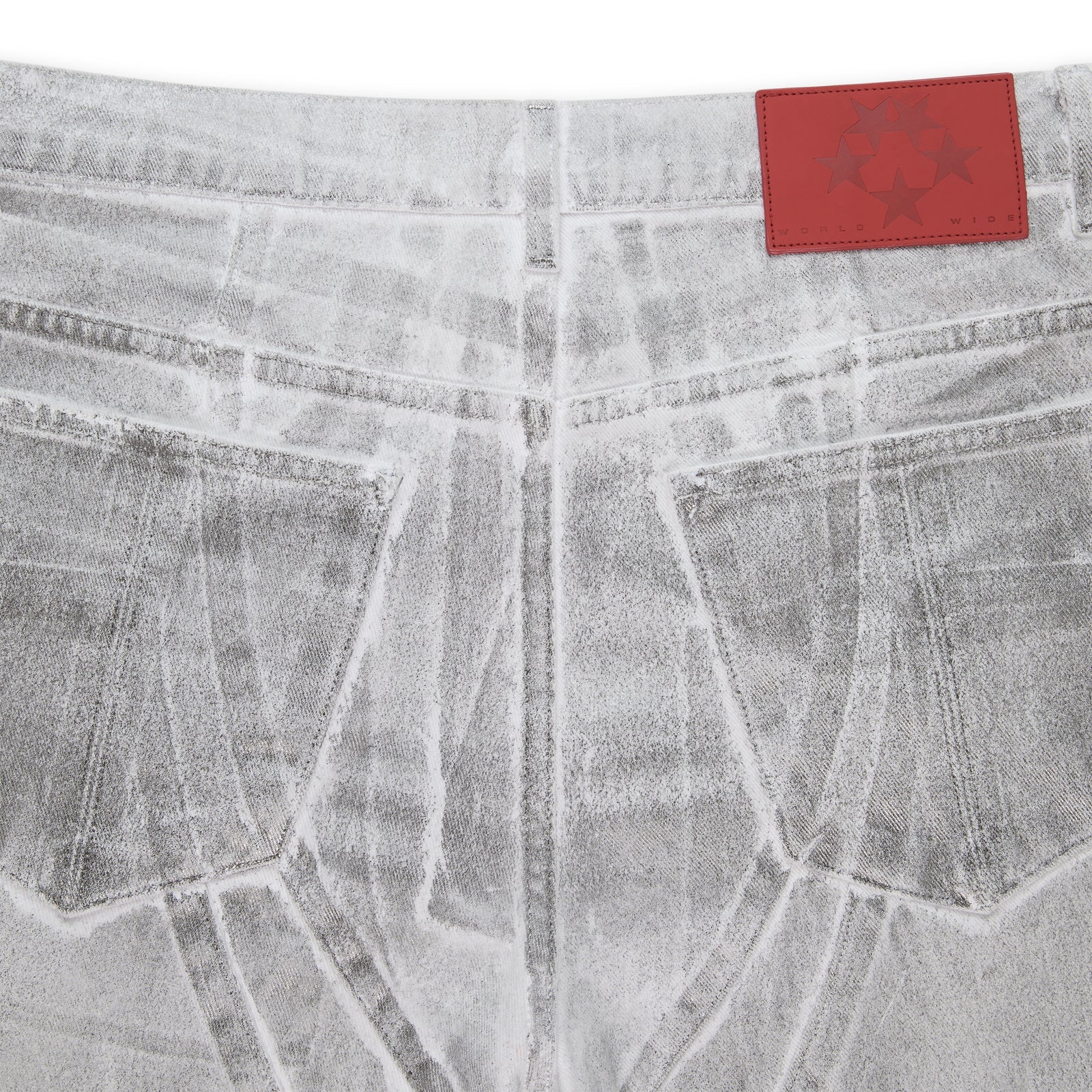 Platinum wide-leg denim pant with spray effect, back pockets, and a red branded leather patch.