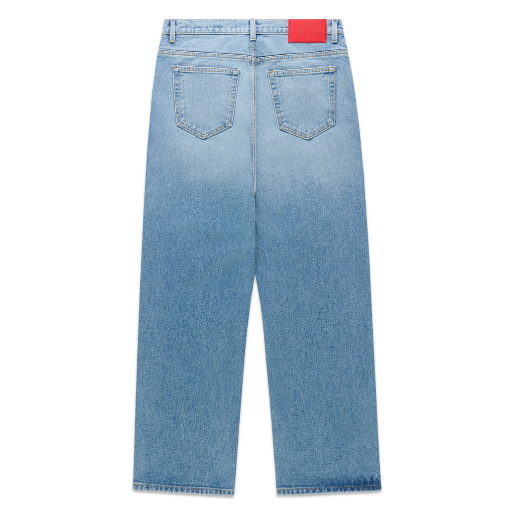 Vintage wash blue denim jeans with a red branded leather back patch and classic straight leg fit.