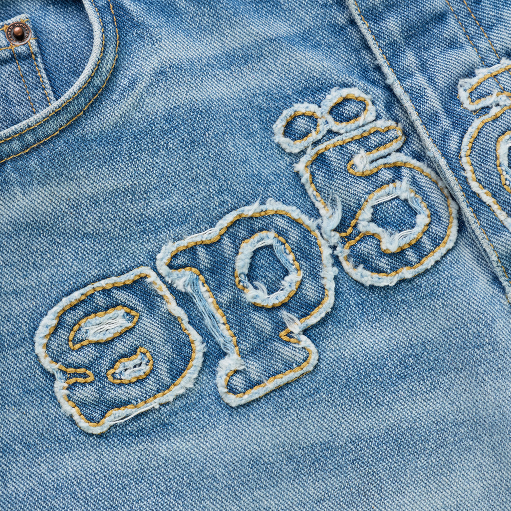 Distressed vintage wash denim with frayed embroidered "SP5DER" logo.