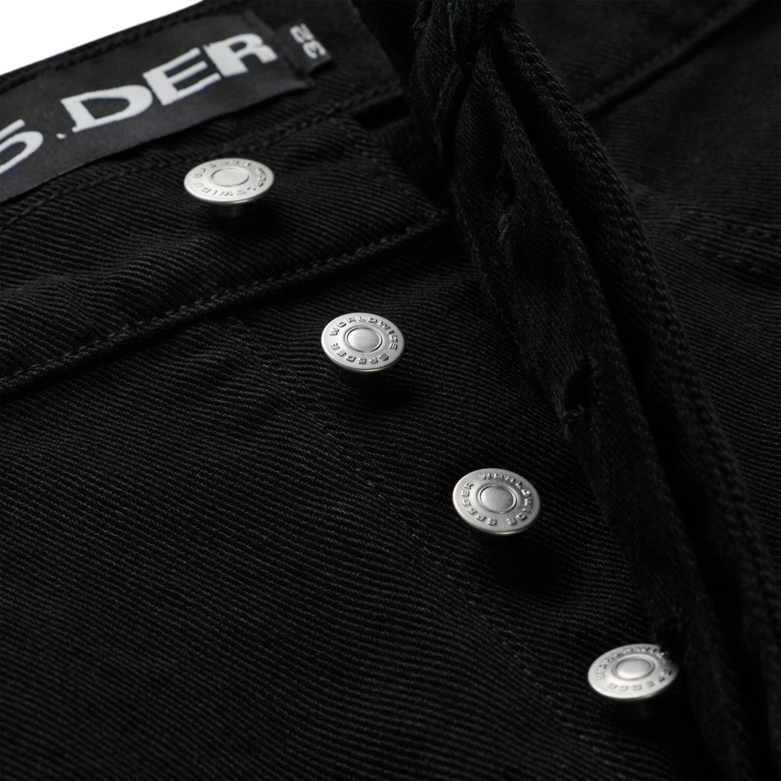 Close-up of OXY JEAN's black 13oz denim fly with branded silver shank buttons and black waistband.