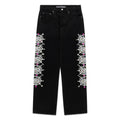 Black 13oz denim pants with vintage wash, white web print, and colorful rhinestone embellishments down both legs.