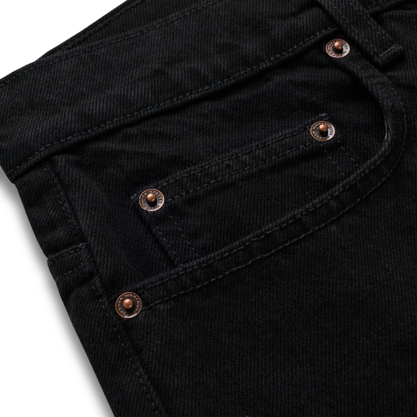 Close-up of black 13oz denim pants with custom branded copper hardware on front pockets.