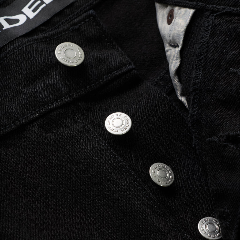 Close-up of black 13oz denim pants with branded silver shank buttons on the fly.