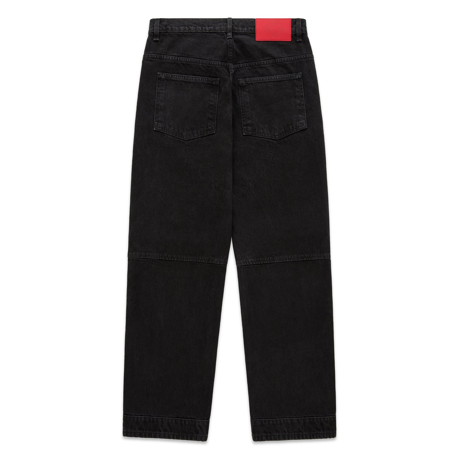 Faded black denim jeans with paneled knees, back pockets, and a red branded leather patch.