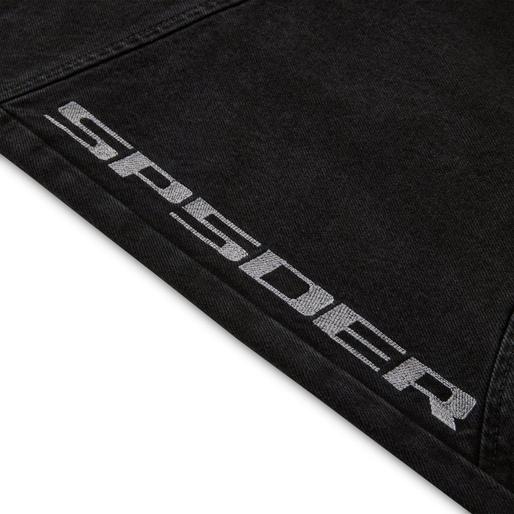 Close-up of black faded wash denim pant with "SP5DER" logo printed on the leg.
