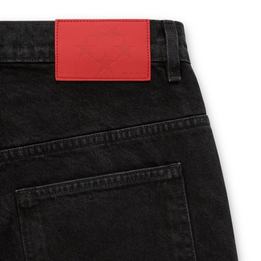 Black faded wash denim with red branded leather back patch featuring embossed stars.