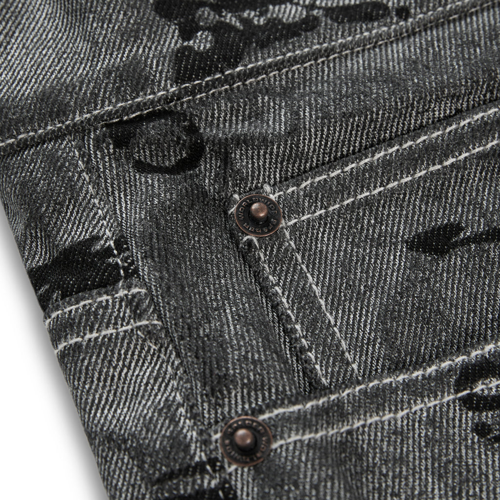 Washed black denim pants with all-over print, red contrast stitching, belt loops, and branded SP5DER hardware.