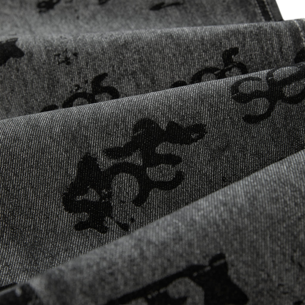 Gray denim pants with black all-over print design and red contrast stitching.