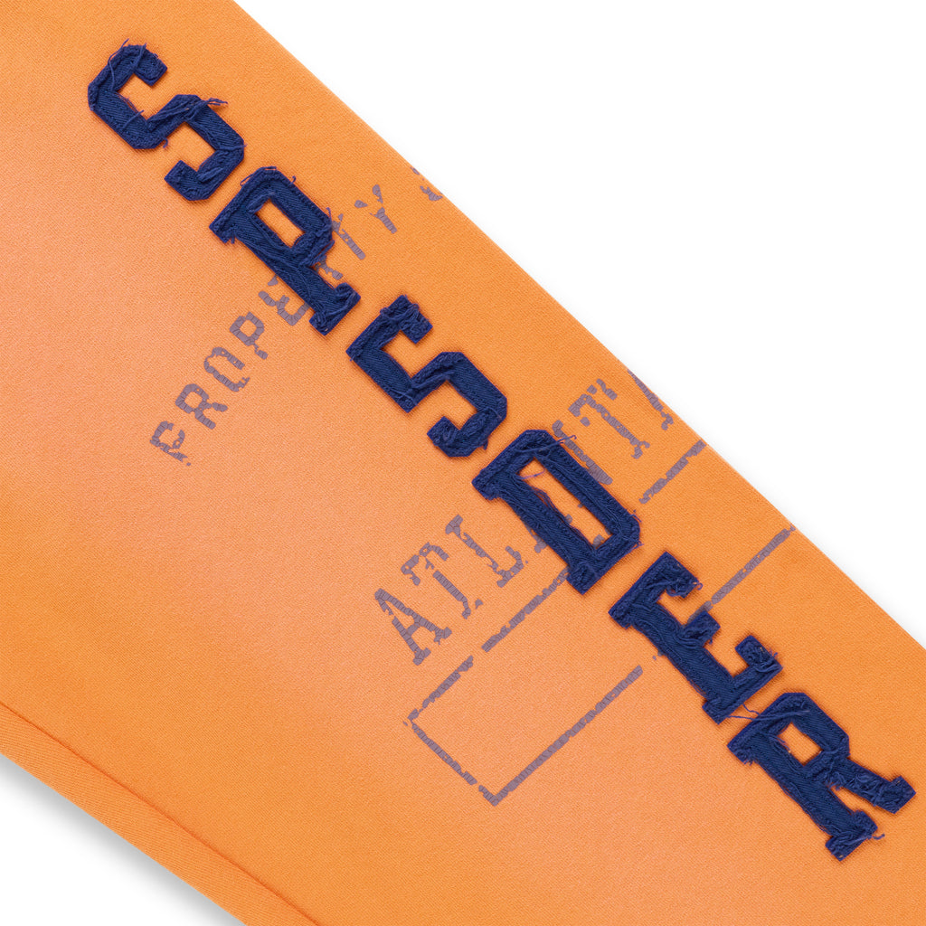 Orange cotton fleece sweatpant with raised, frayed blue "SPSDER" lettering and faded graphic print.