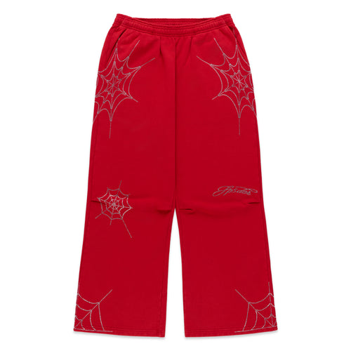 Red cotton fleece sweatpants with rhinestone spider web and text details, wide-leg silhouette.