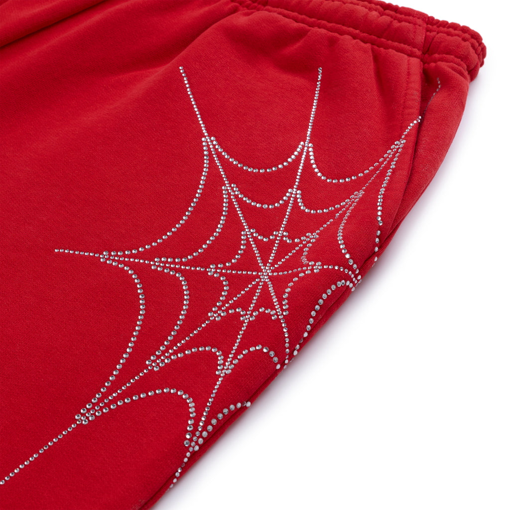 Red cotton fleece sweatpants with a sparkling rhinestone spider web design.