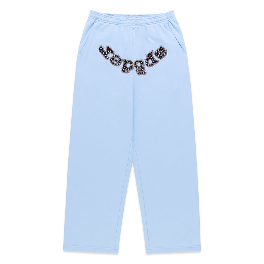 Light blue cotton fleece sweatpants with a wide-leg silhouette and a studded OG logo appliqué across the crotch.