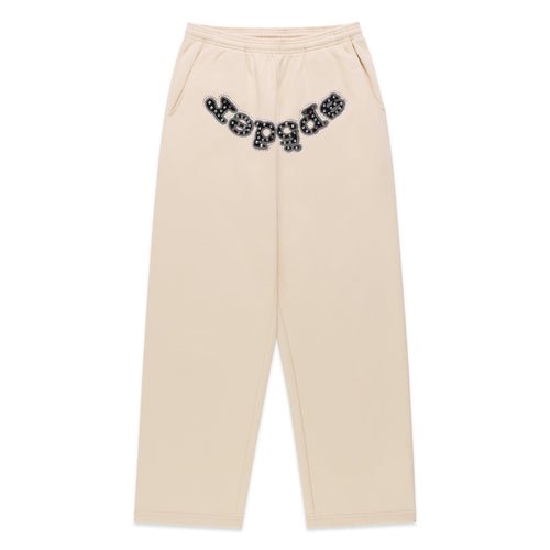 Beige cotton fleece sweatpants with "OG LOGO" appliqué across the crotch, embellished with mixed metal studs.