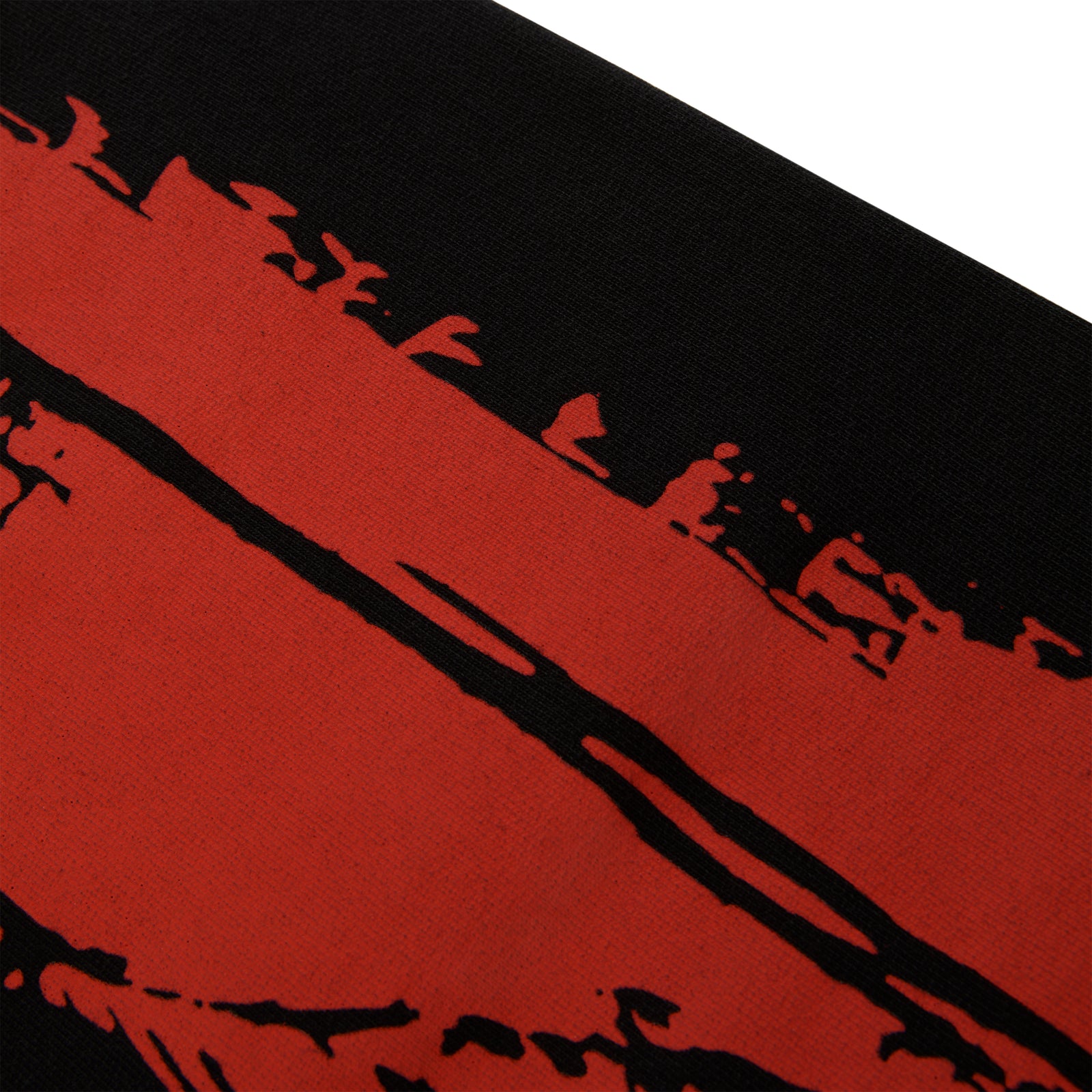 Close-up of black 13oz cotton fleece sweatpant with red painted moto design.