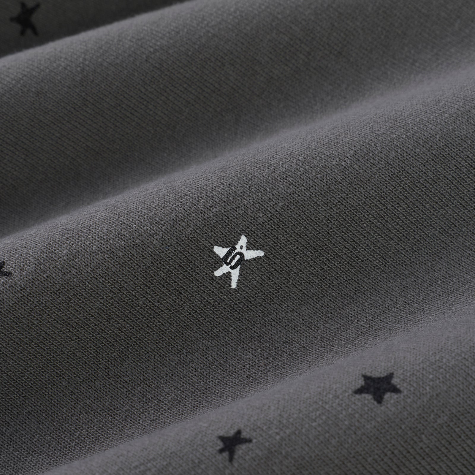 Dark gray 100% cotton fleece sweatpants with white puff print 'SP5DER' star and scattered black stars.