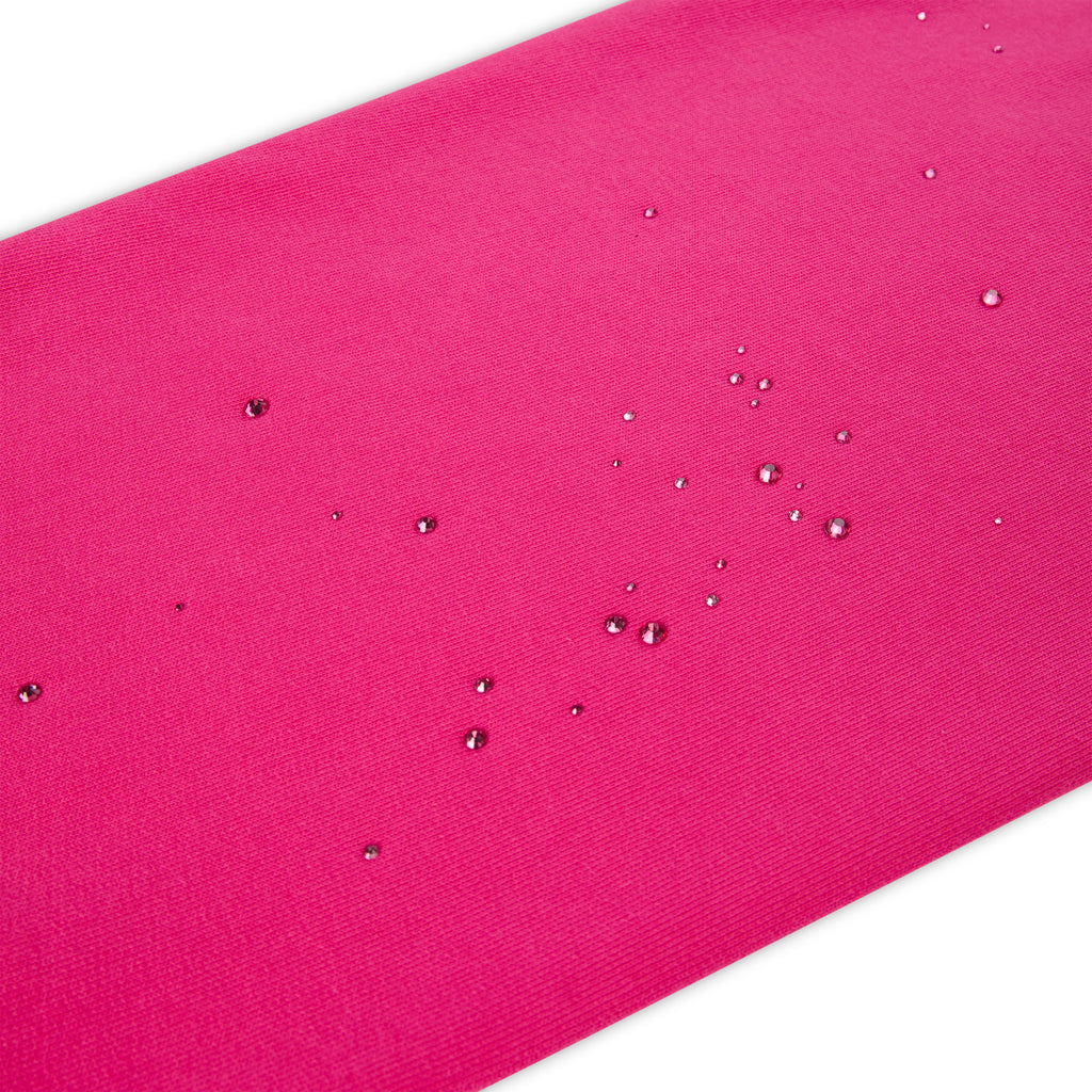 Close-up of a vibrant pink fabric with scattered water droplets, showcasing its water-resistant texture.
