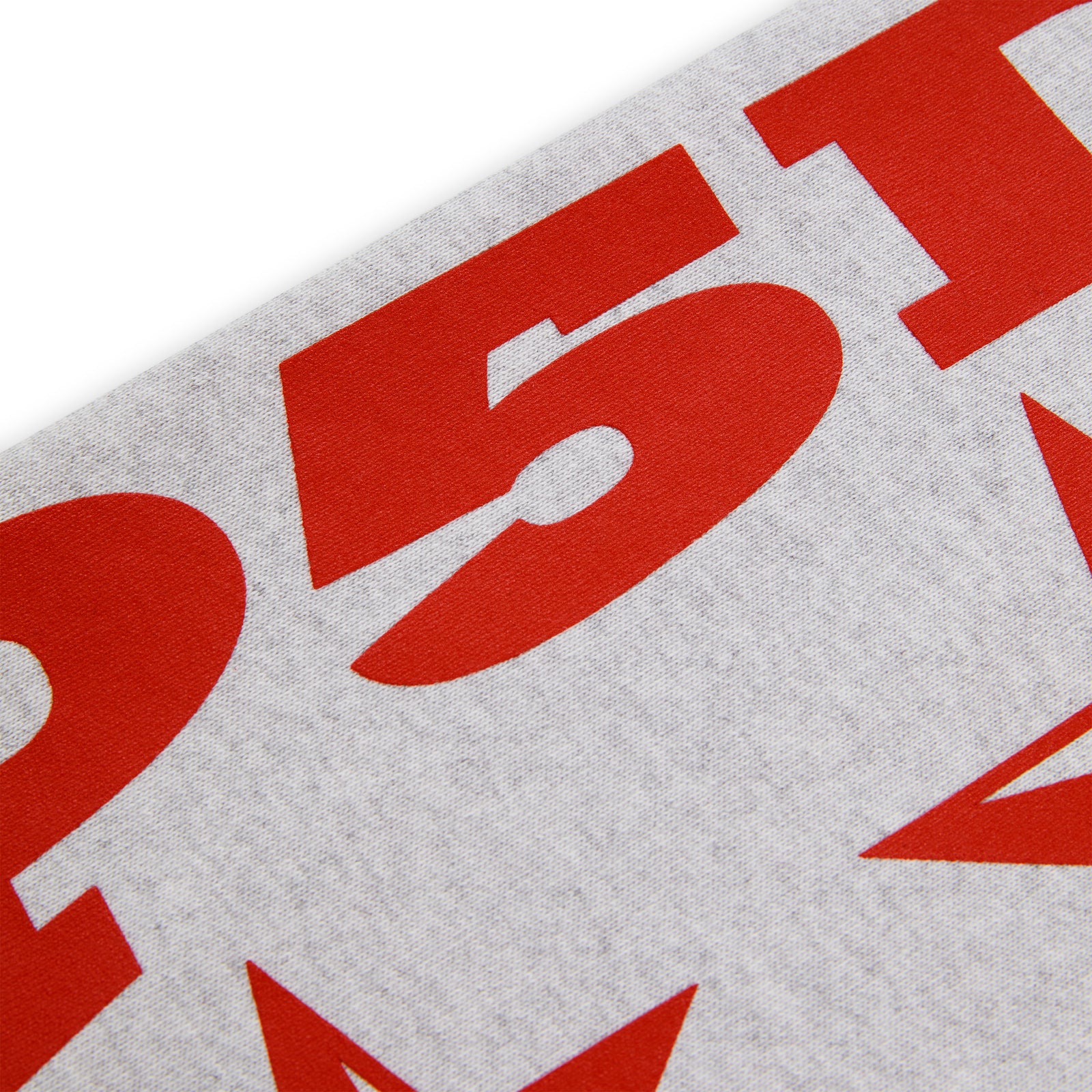 Close-up of a light grey 100% cotton fleece hoodie sleeve with bold red "5P1" and star print.