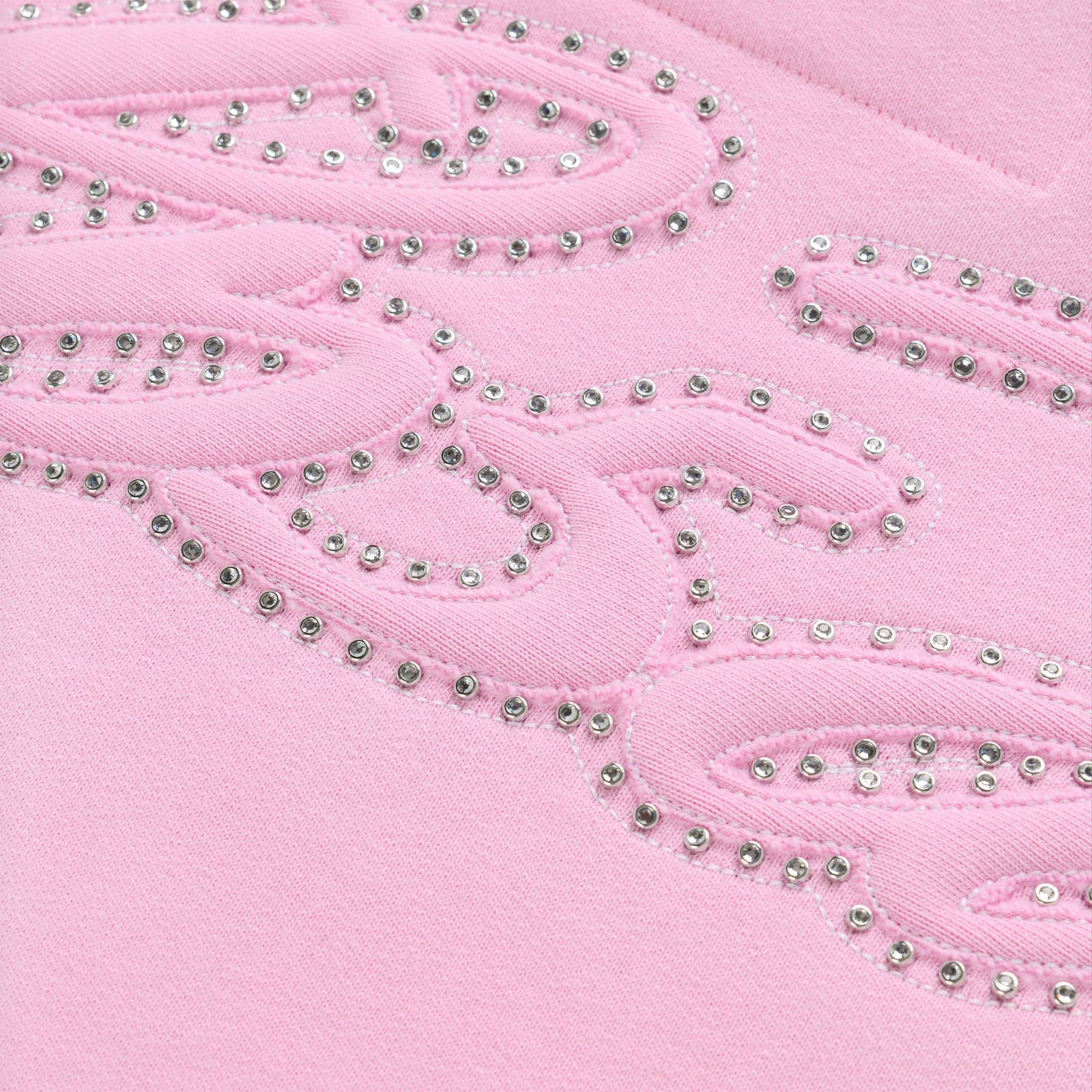 Close-up of a pink cotton fleece hoodie with a rhinestone-lined script design.