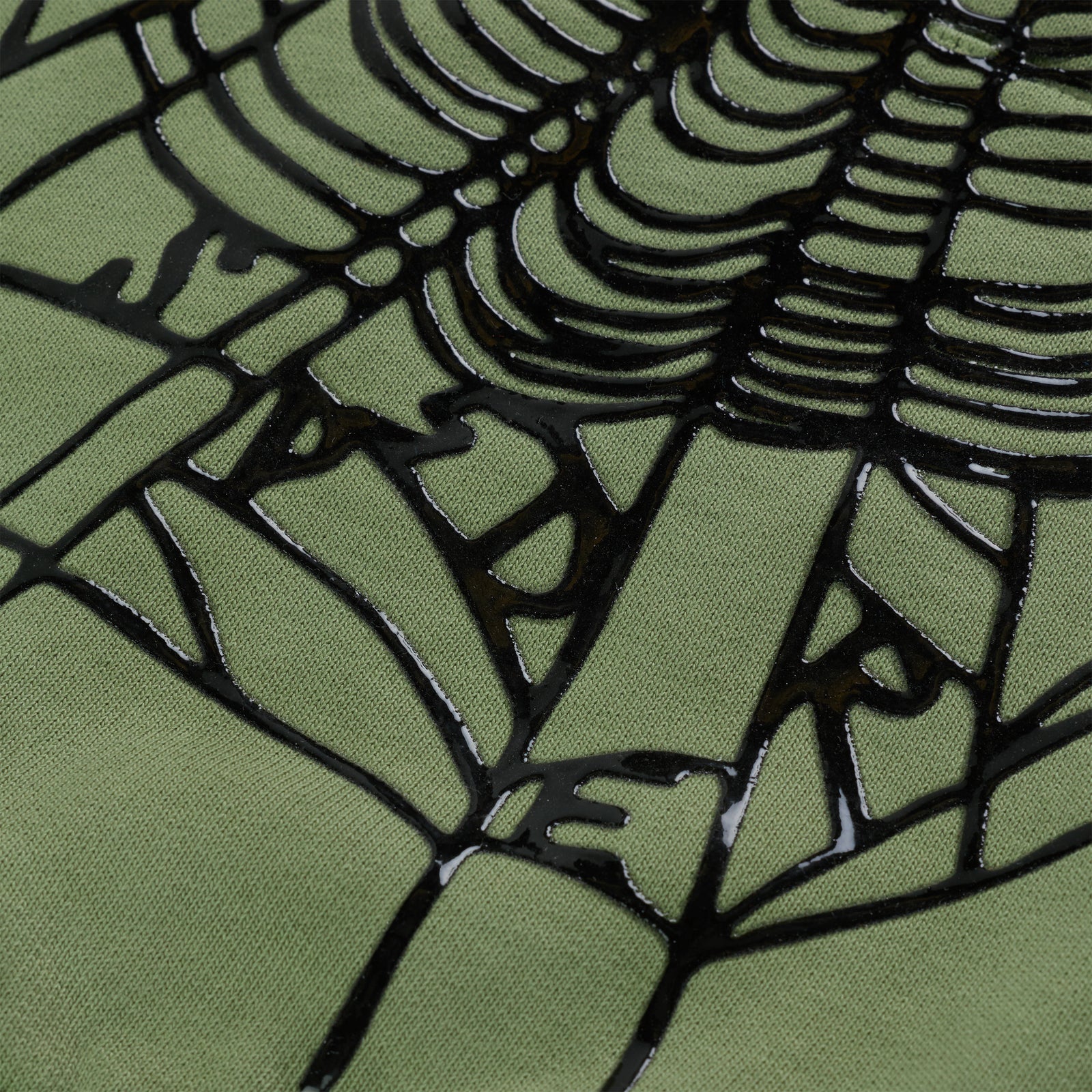 Close-up of OG Web Ombre Hoodie, showing black puff print spiderweb on green 100% cotton fleece.
